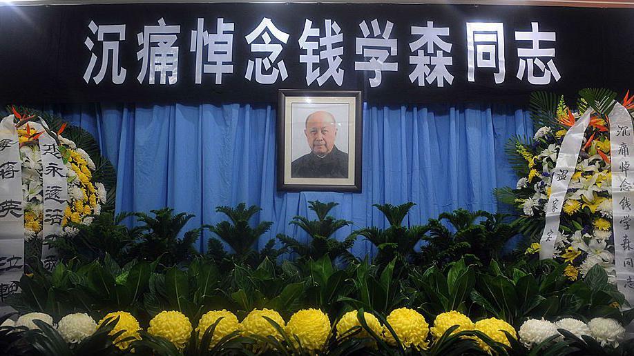 Una foto de Qian Xuesen y flores en su funeral.
