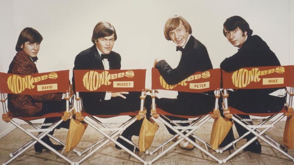 El grupo pop The Monkees, formado por Davy Jones, Micky Dolenz, Peter Tork y Mike Nesmith, posa en sus sillas de director para la serie de televisión de 1966-68.