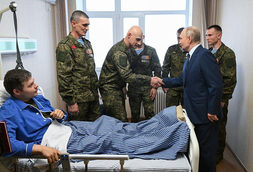 Una fotografía de archivo difundida por la agencia estatal rusa Sputnik muestra a Vladimir Putin estrechando la mano de cinco soldados uniformados que rodean la cama de un paciente.