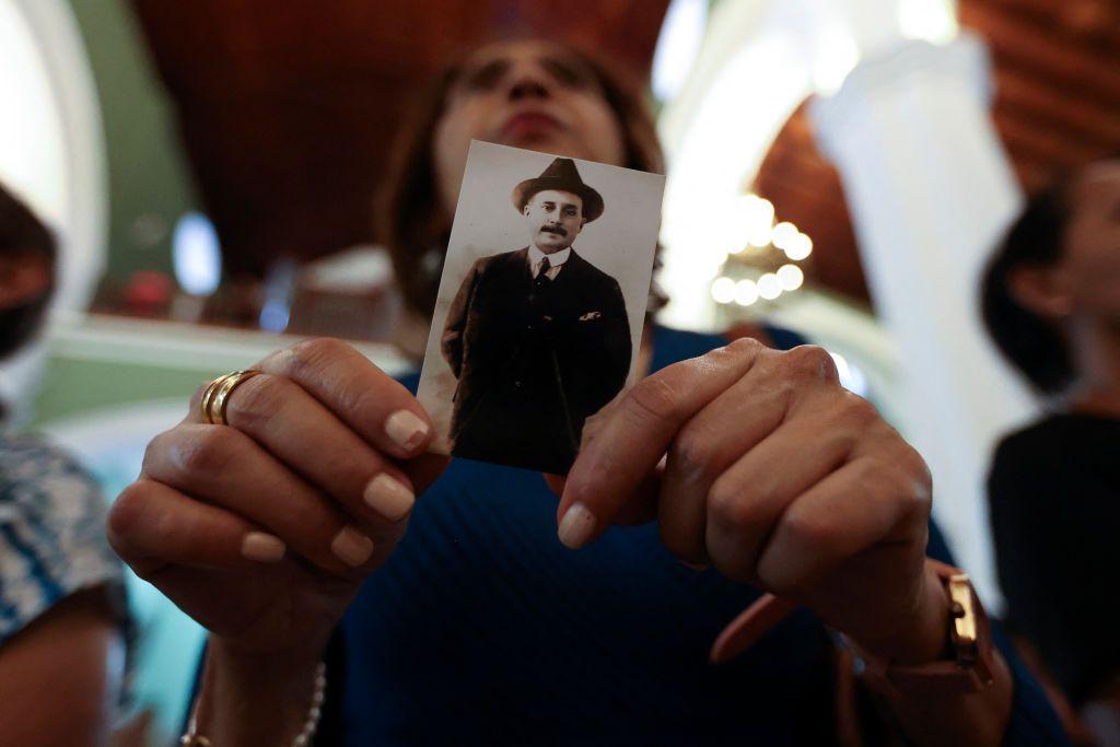 Una mujer sostiene una estampa de José Gregorio Hernández
