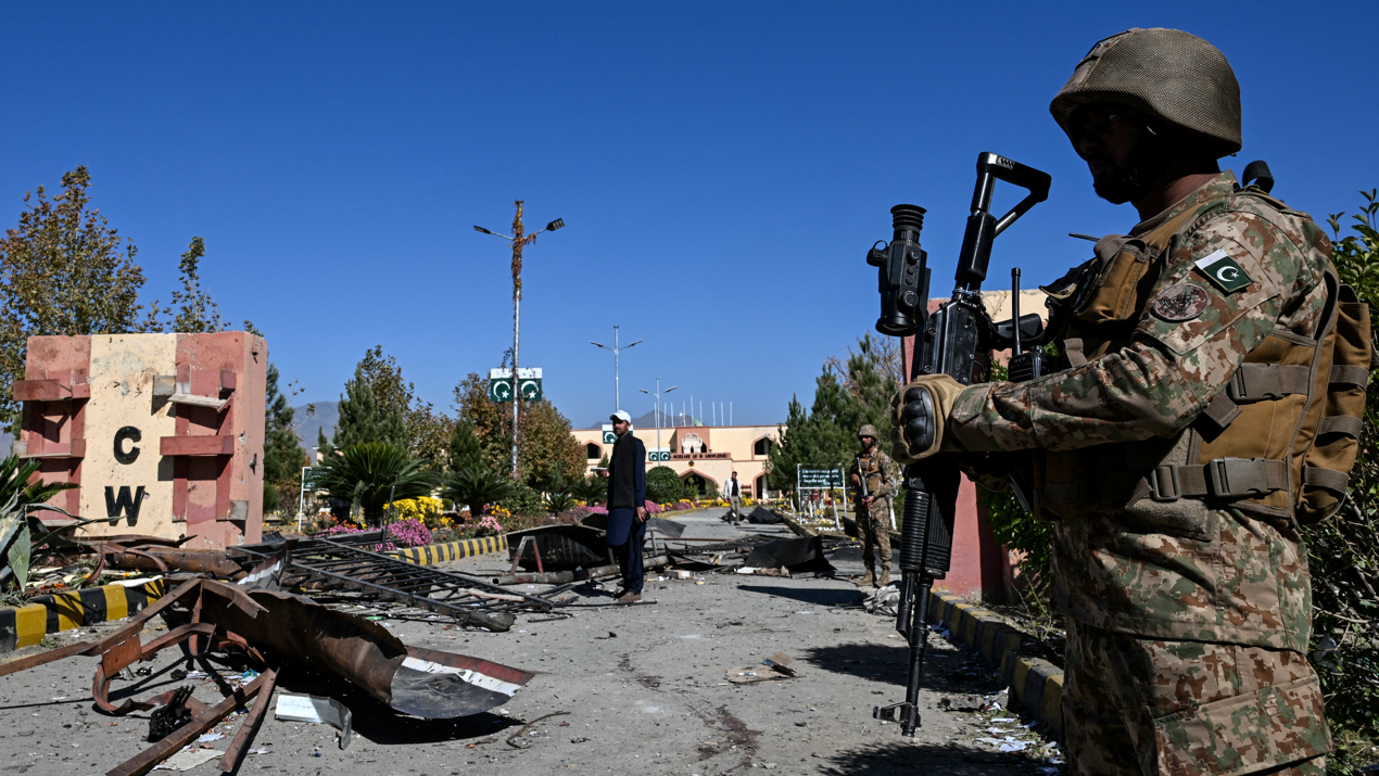 پاکستانی فوج کے اہلکار وانا کیڈٹ کالج کے داخلی دروازے پر کھڑے ہیں جو دہشتگردوں کے حملے میں تباہ ہو چکا ہے۔ 