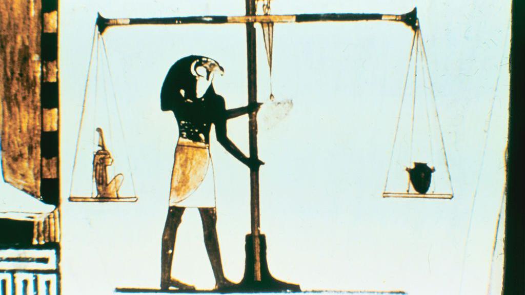 رسم للإله حورس لدى المصريين القدامى رجل جسده أسود اللون و برأس صقر يمسك بميزان ضخم 