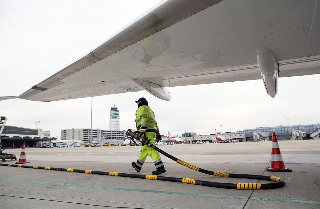 Hombre cargando una manguera bajo un avión