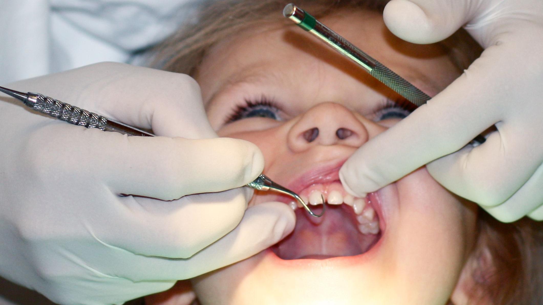 Una niña siendo vista por un dentista.