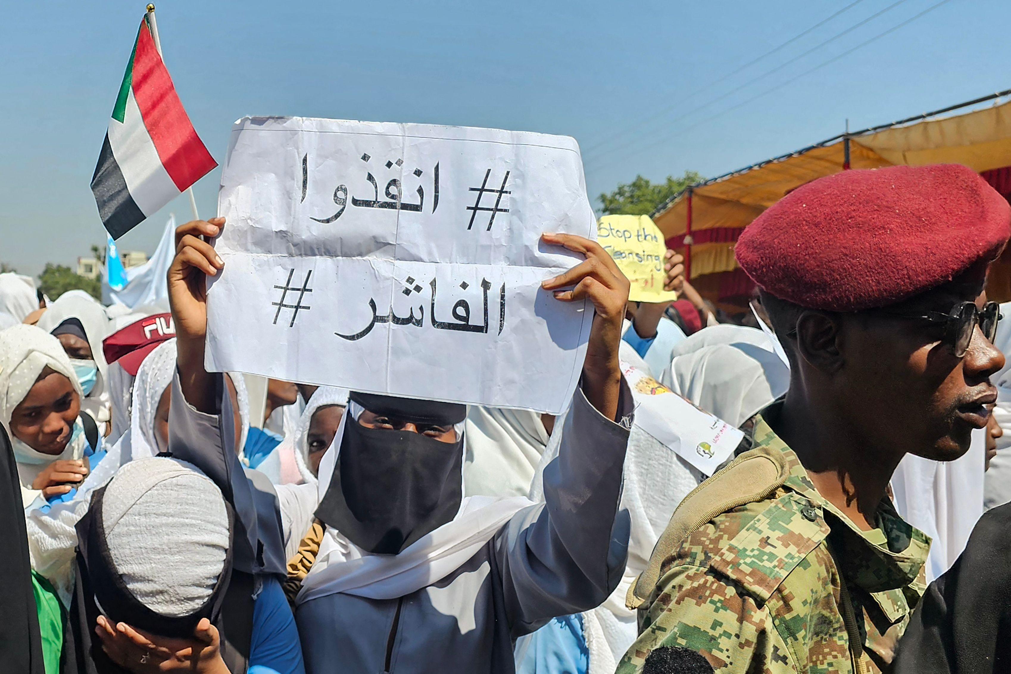 متظاهرة سودانية ترفع لافتة تطالب بإنقاذ الفاشر، خلال وقفة احتجاجية في القضارف في 6 نوفمبر/تشرين الثاني 2025.