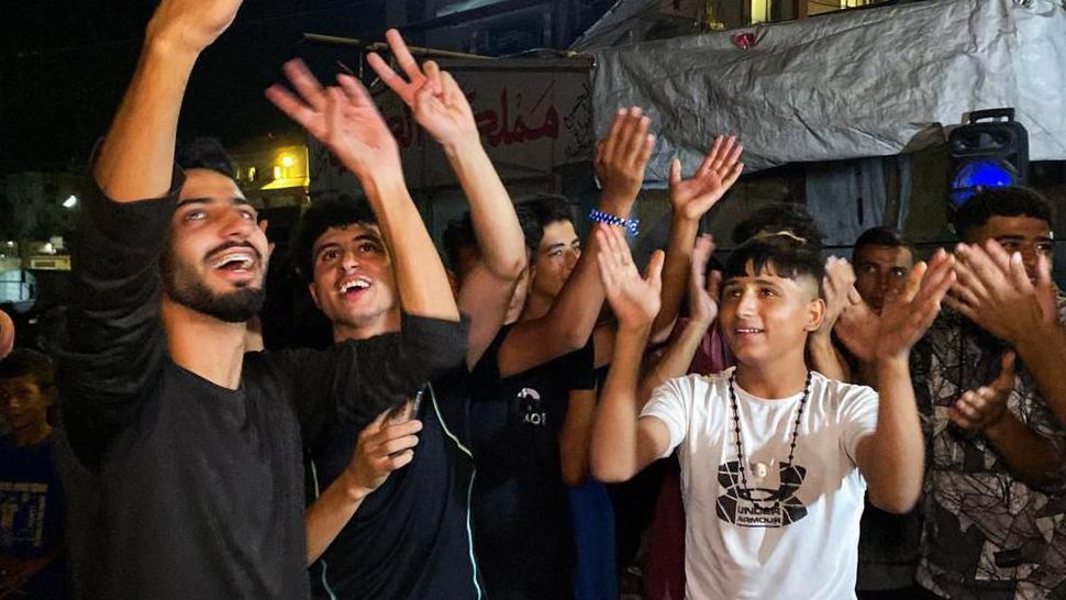 Personas celebran el anuncio de un posible alto al fuego en gaza. La foto fue tomada en Jan Yunis, en el sur de la Franja.