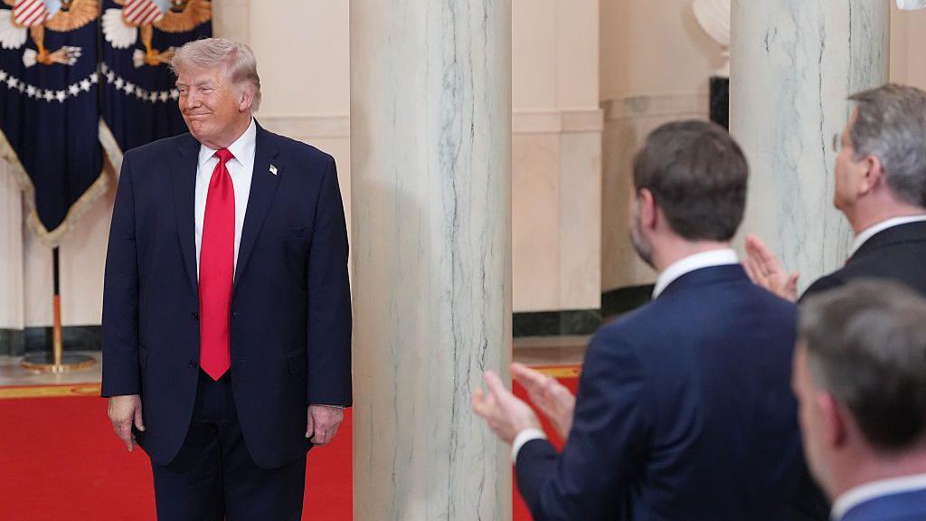 El presidente de los Estados Unidos, Donald Trump, saluda a los asistentes tras pronunciar un discurso desde el Salón Transversal de la Casa Blanca el 1 de abril de 2026, en Washington, DC.