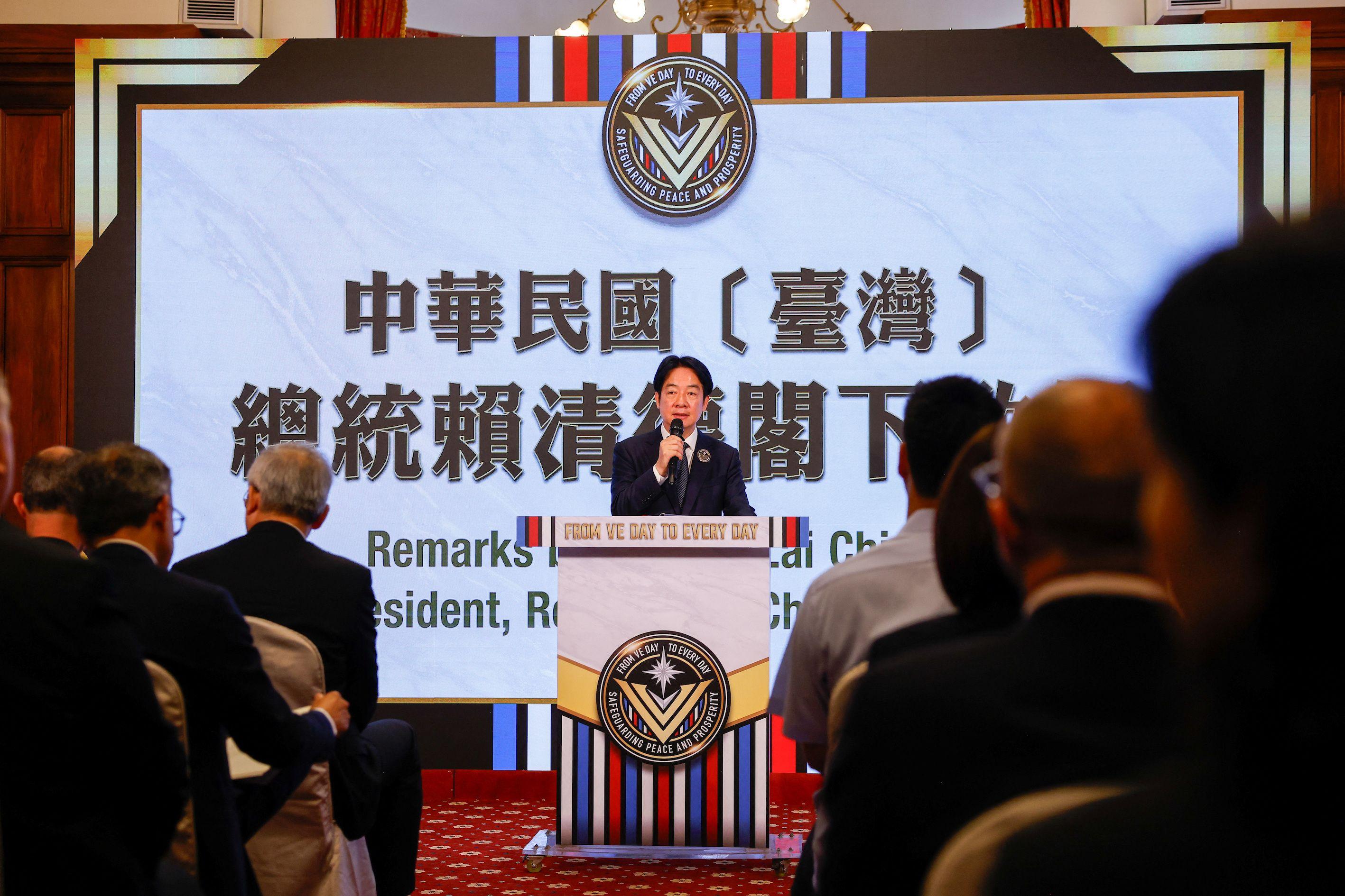 台灣總統賴清德在台上演說，一些賓客背對鏡頭坐下聆聽賴清德發言。
