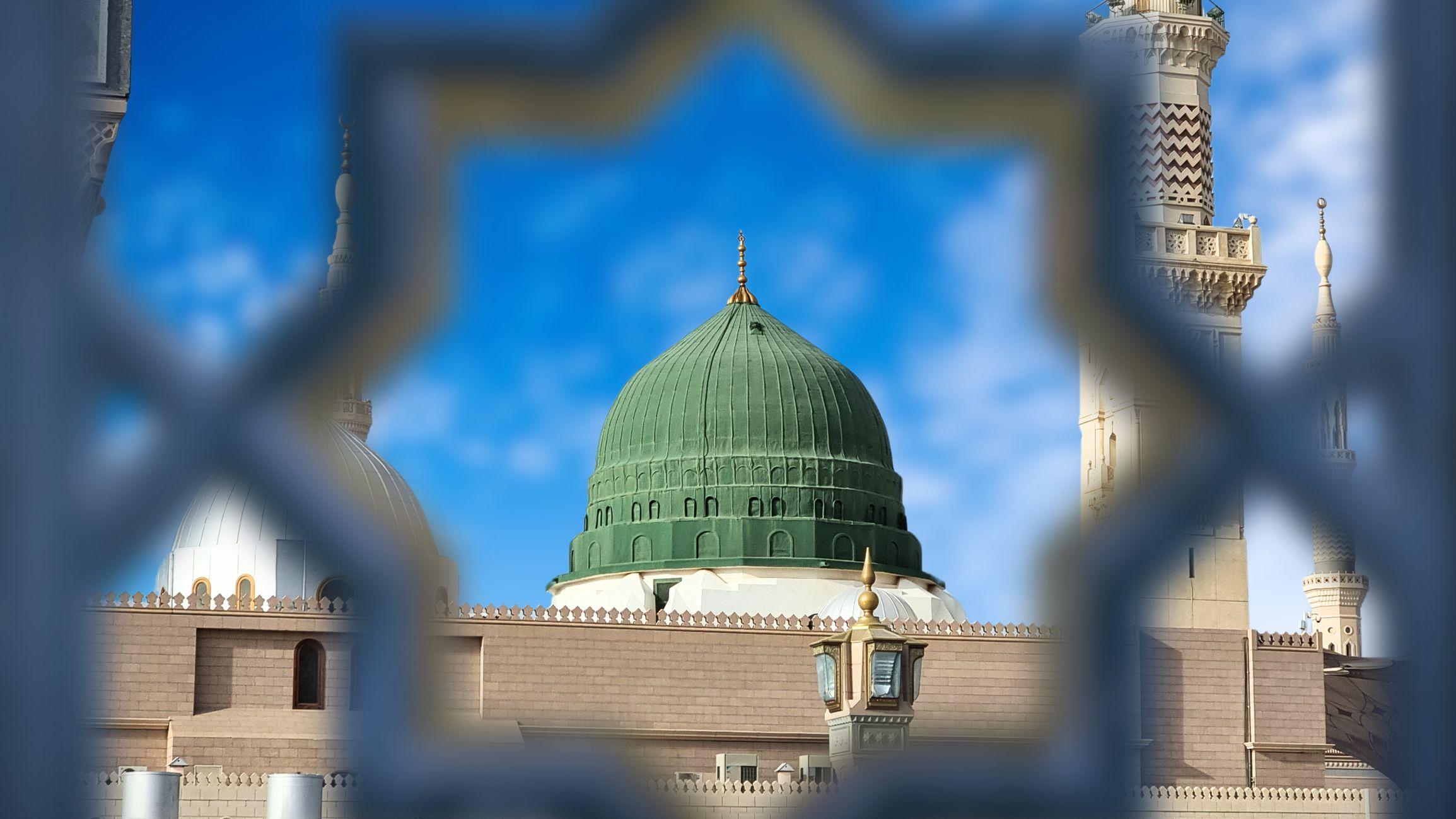 نجمة ثُمانية من سور خارجي تظهر من ورائها القبة الخضراء للمسجد النبوي ثاني أكبر مسجد في العالم وأحد المساجد الثلاثة المقدسة لدى المسلمين، المدينة المنورة - السعودية