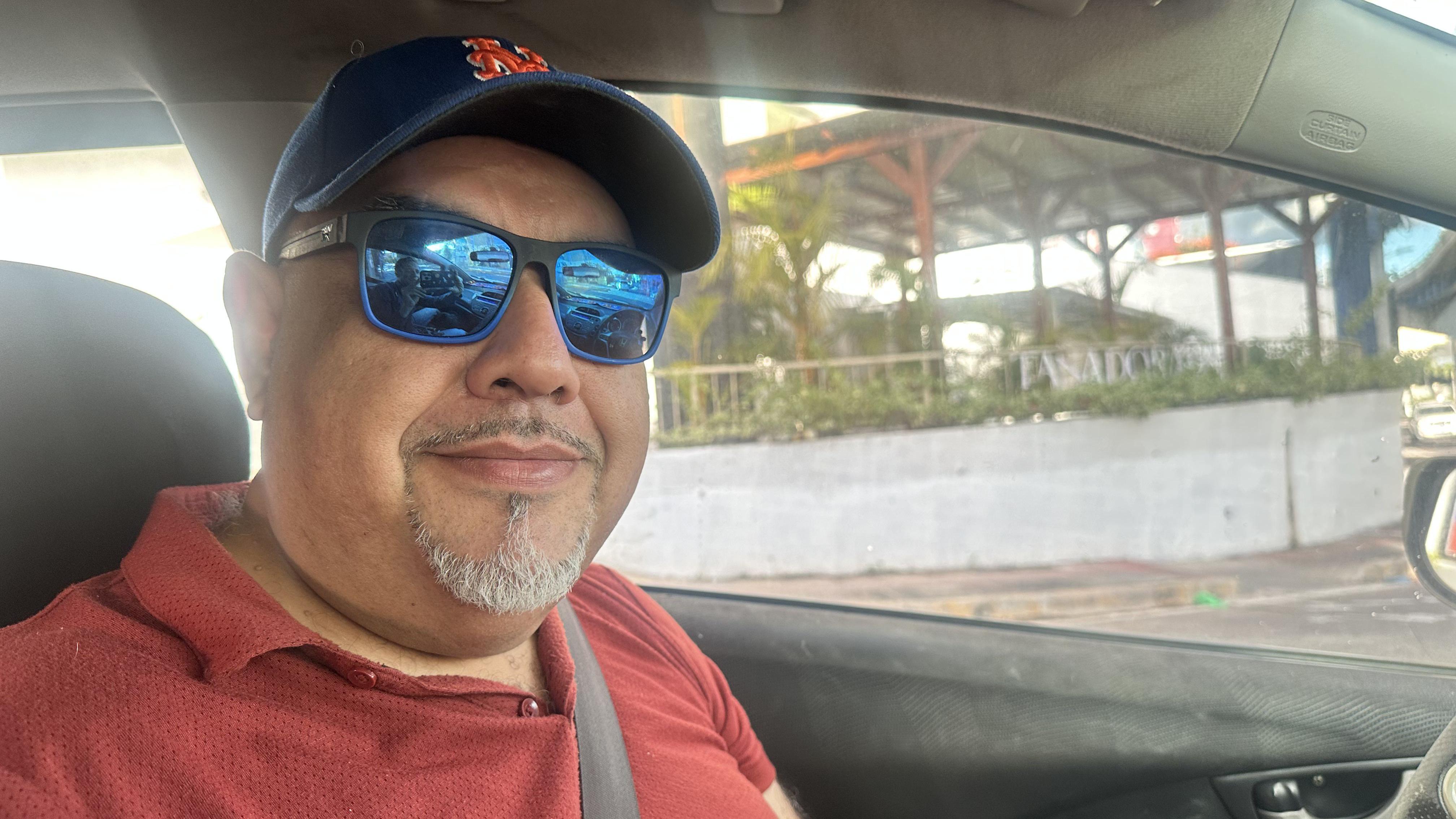 Elías Padilla con lentes de sol sentado en su auto mientras conversa con el corresponsal de la BBC.