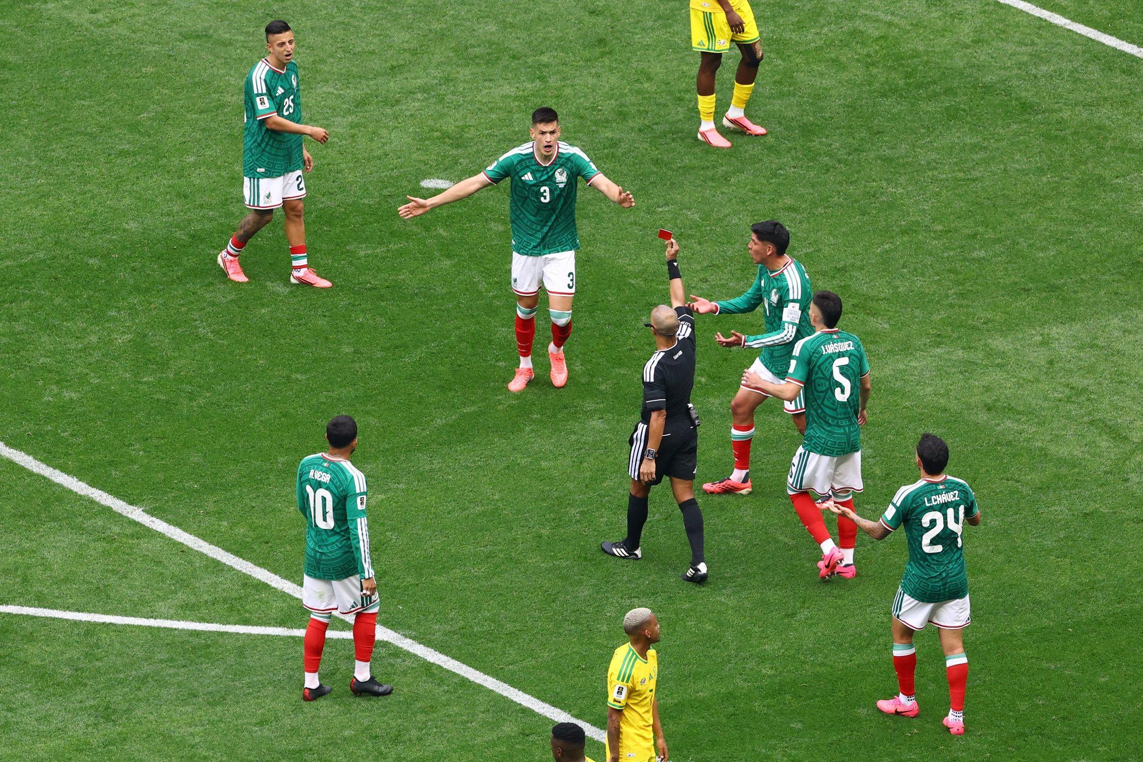 لاعبون من منتخب المكسيك قرب الحكم لحظة إصداره بطاقة حمراء بحق أحد اللاعبين.
