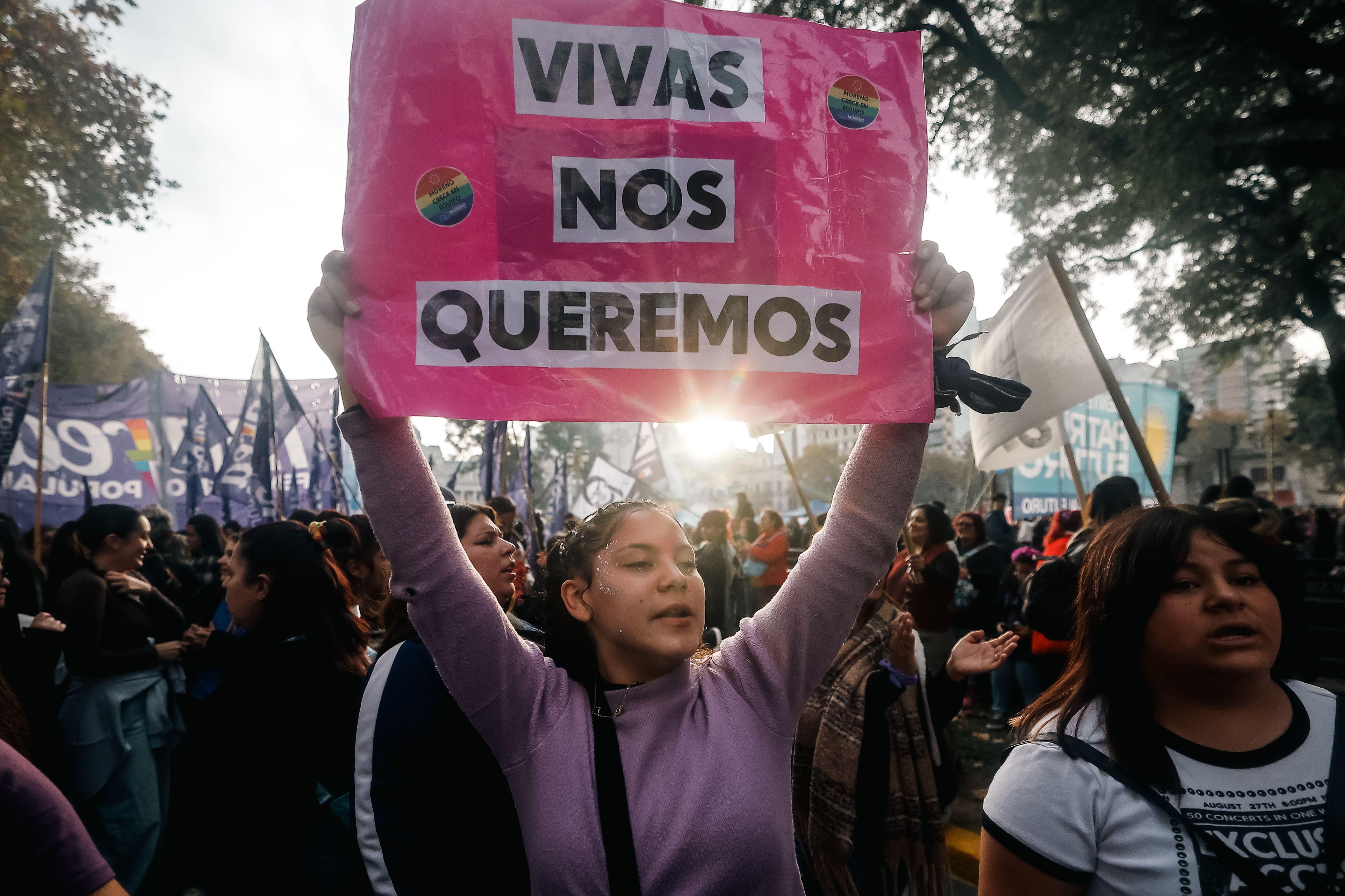 Una chica sostiene un cartel en el que dice "Vivas nos queremos" en una manifestación.