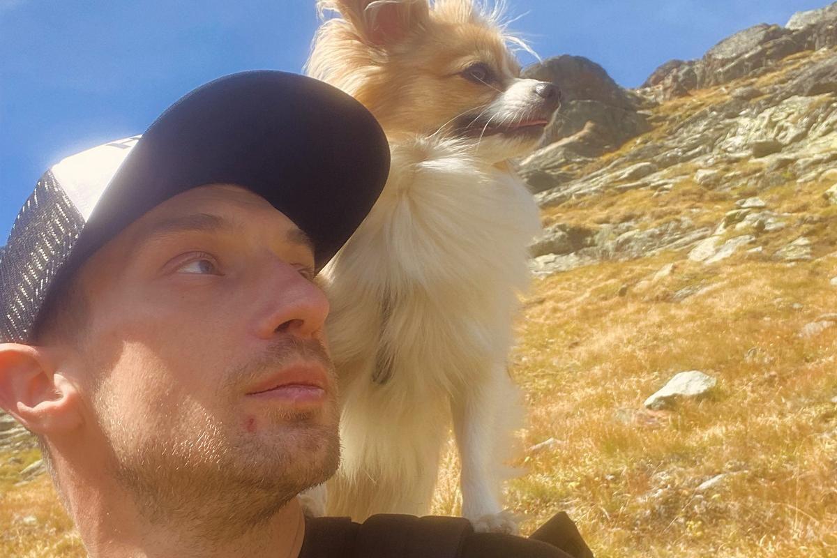 Jan con una gorra azul y con Filip subido en su hombro miran a una montaña.