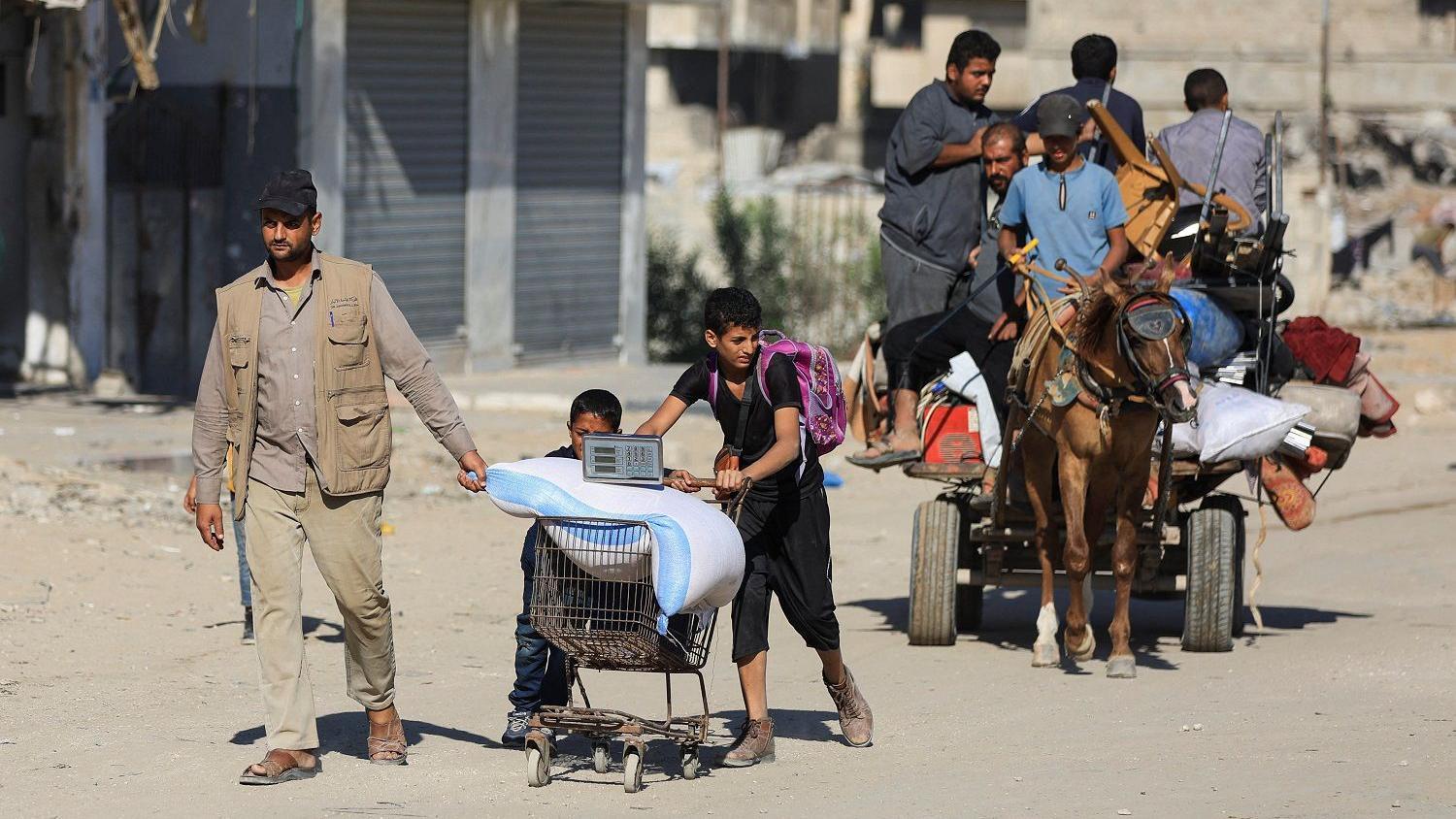 Palestinians, with their belongings, move along a street, amid a ceasefire between Israel and Hamas, in Gaza City, October 15, 2025. REUTERS/Dawoud Abu Alkas