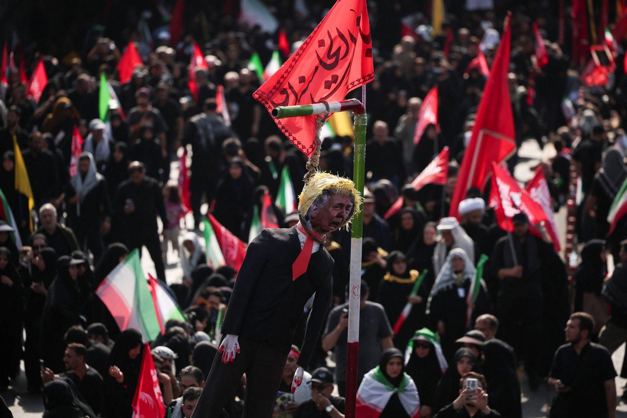 في طهران، إيران، بتاريخ 6 يوليو/تموز 2026، قام المشيعون بتعليق دمية تمثل الرئيس الأمريكي دونالد ترامب خلال تجمعهم في يوم جنازة المرشد الأعلى الإيراني الراحل آية الله علي خامنئي، الذي قُتل في 28 فبراير/شباط في غارات جوية إسرائيلية وأمريكية.