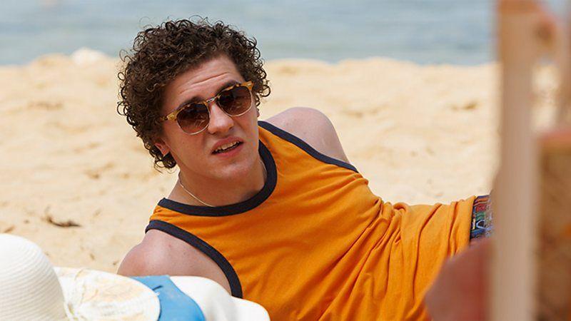 Dylan Llewellyn como Jack Rooke, deitado na praia em cena de 'Big Boys'