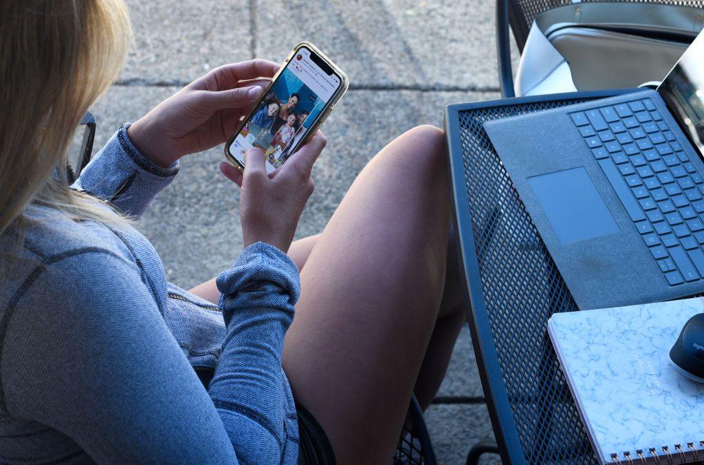 Una joven mirando Instagram en un celular