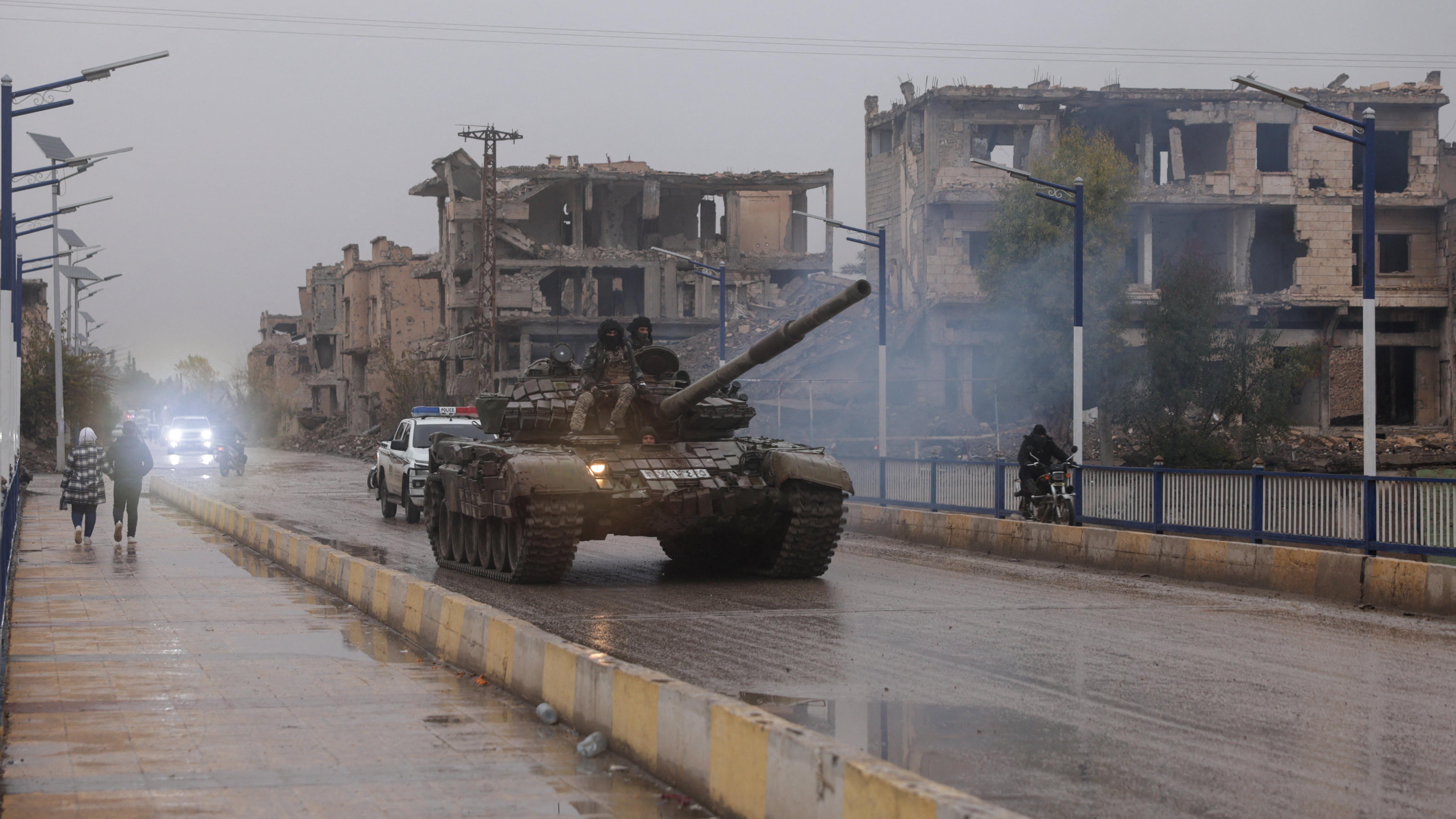 يجلس أفراد عسكريون فوق دبابة، بعد انسحاب قوات سوريا الديمقراطية من محافظة دير الزور وسيطرة الجيش السوري الكاملة على المنطقة، في دير الزور، سوريا.