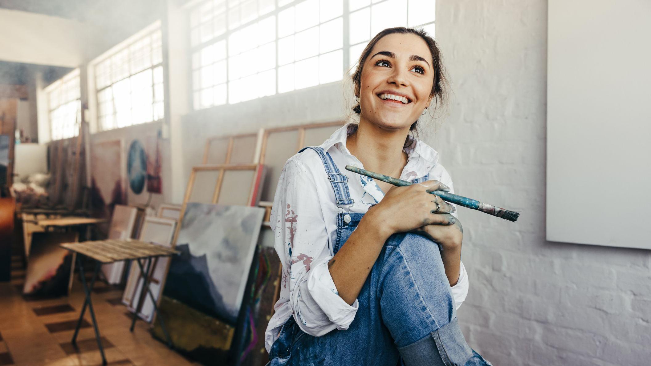 Mujer sonriendo en un estudio de pintura 