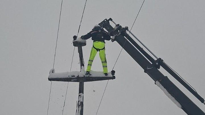 radnik popravlja dalekovod