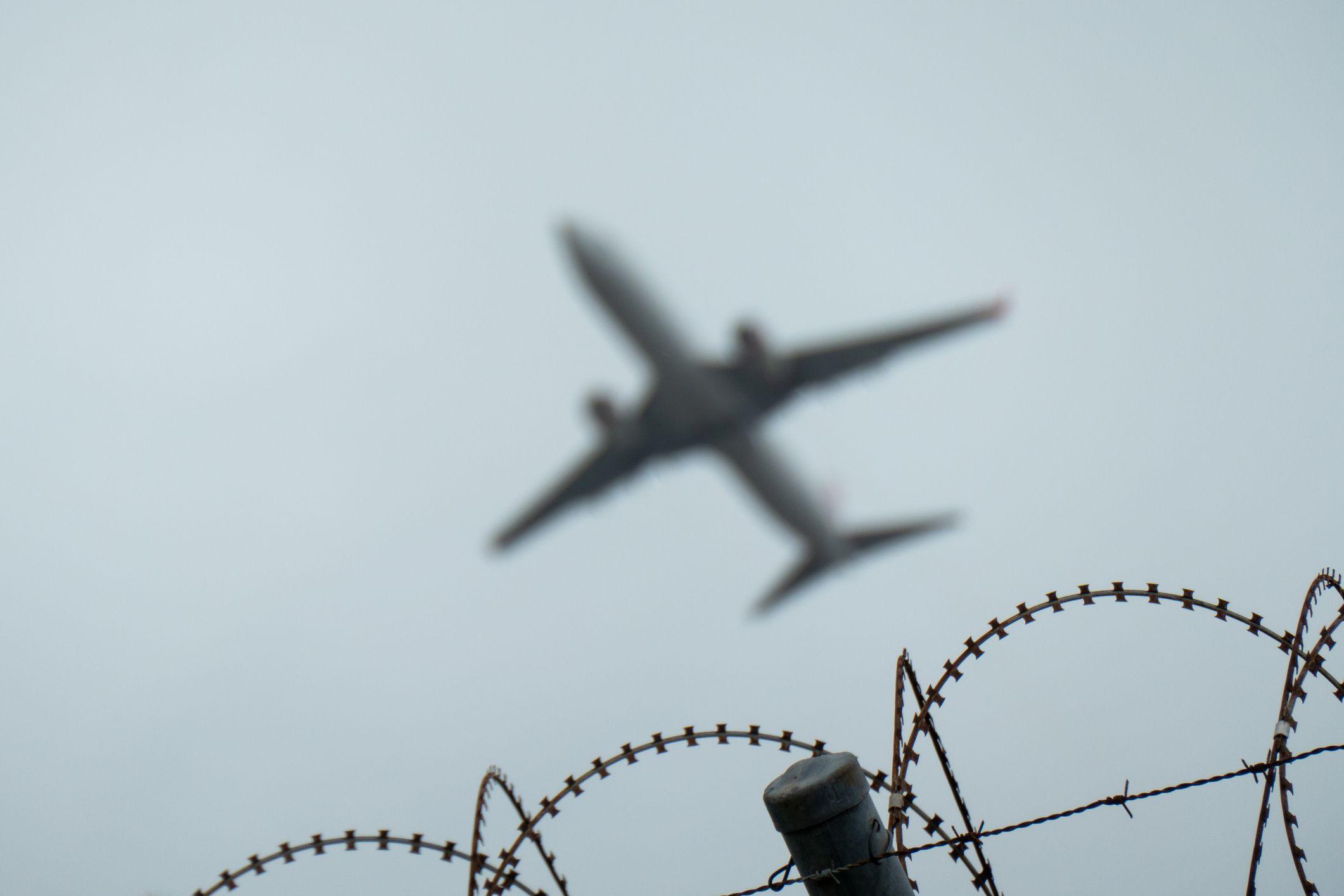 Avión sobre una valla de seguridad.