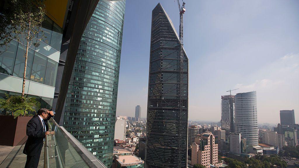 Un hombre mira desde un balcón del edificio BBVA Bancomer hacia la Avenida Reforma, donde se alzan las torres de oficinas Torre Mayor (izquierda) y Torre Reforma (centro), en la Ciudad de México.