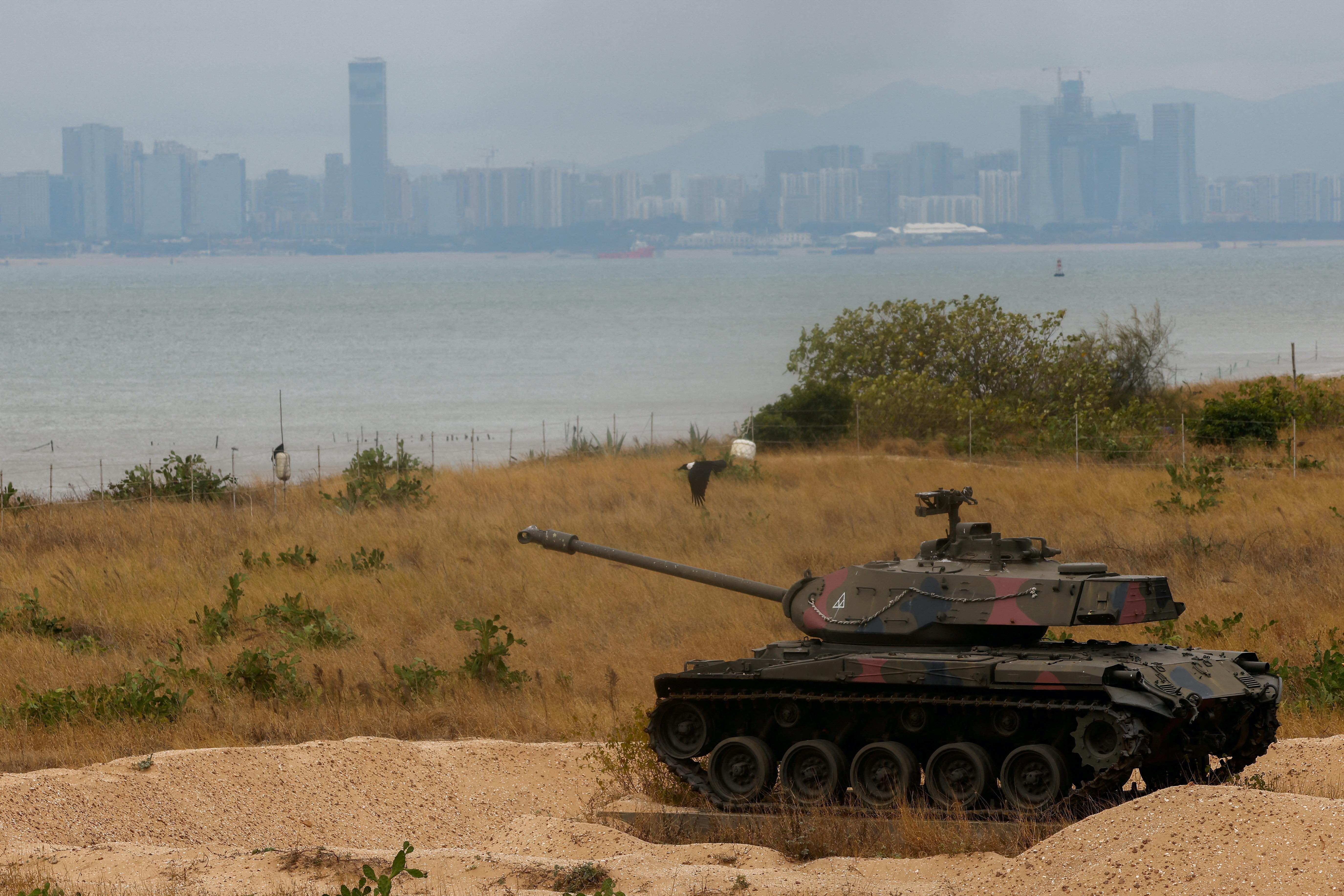 Um tanque de guerra próximo ao mar, com vista da China do outro lado