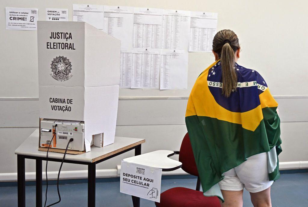 Una mujer envuelta en la bandera de Brasil vota en las elecciones generales del en 2022.