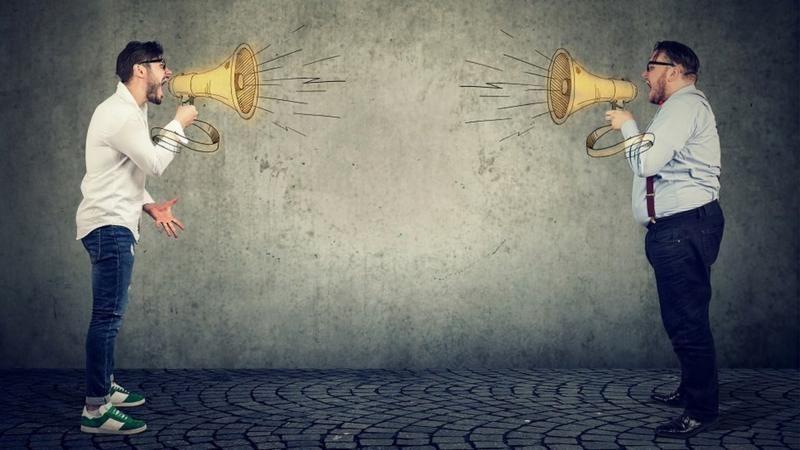 شخصان يواجه كل منهما الآخر في تحدٍ ويمسك كل منهما بوقاً يصرخ فيه