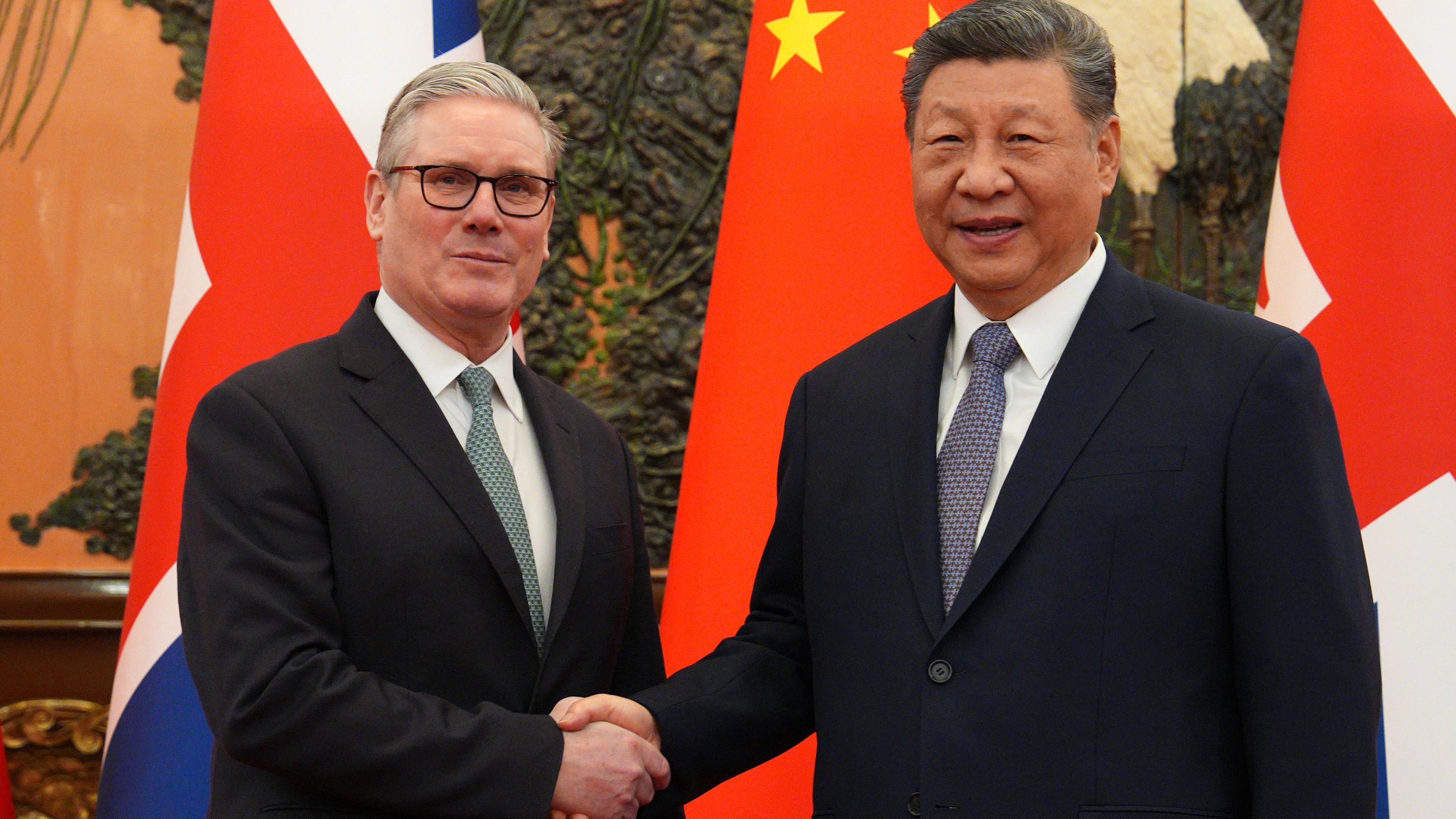 施紀賢（左）與習近平（右）在北京人民大會堂握手，背景是兩國國旗（29/1/2026）