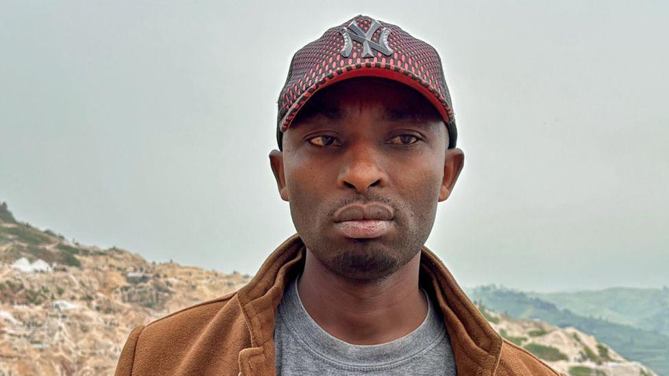 O supervisor da mina de Rubaya, Patrice Musafiri, fotografado na mina com montanhas ao fundo