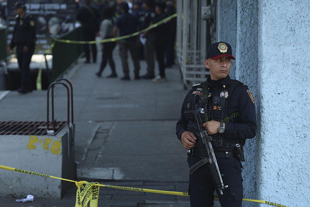 Un policía armado con un fusil vigila en una zona acordonada tras el ataque a los funcionarios.
