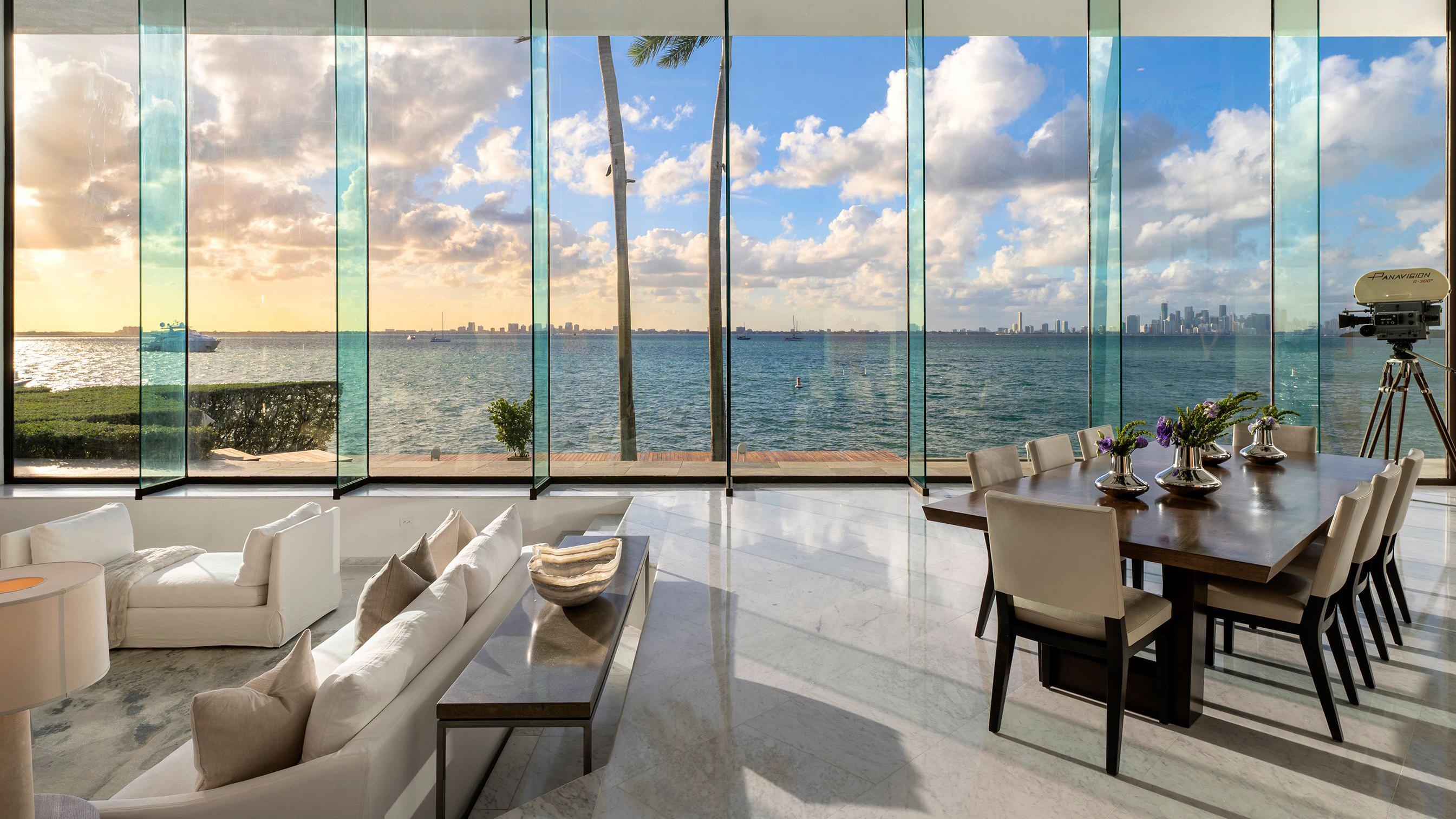 La sala de la casa de John Daveney en Key Biscayne: tiene unos enormes paneles de vidrio desde los que se ve la ciudad de Miami al fondo. 