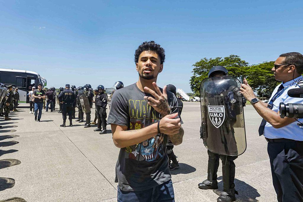 Un venezolano detenido gesticula caminando para abordar el vuelo a Venezuela como parte de un acuerdo de intercambio de detenidos entre Venezuela y Estados Unidos.