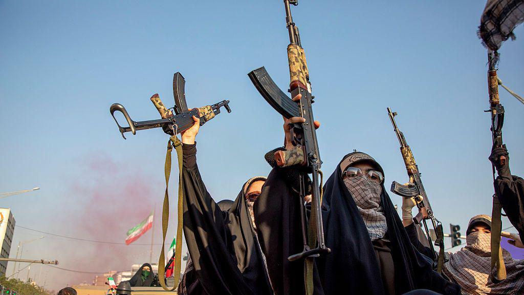 Mulheres seguram rifles durante uma manifesta&ccedil;&atilde;o pr&oacute;-governo do Dia do Ex&eacute;rcito Nacional, em 17 de abril de 2026, em Teer&atilde;, Ir&atilde;. Em 8 de abril, o presidente dos EUA, Donald Trump, anunciou um cessar-fogo de duas semanas entre os EUA e o Ir&atilde;. As negocia&ccedil;&otilde;es de paz, facilitadas pelo Paquist&atilde;o, ainda n&atilde;o produziram uma solu&ccedil;&atilde;o duradoura, sendo as principais quest&otilde;es pendentes as capacidades nucleares do Ir&atilde; e o controle do Estreito de Ormuz.