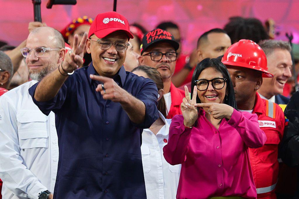 Jorge y Delcy Rodríguez haciendo la señal que supuestamente es similar a la firma de Chávez.