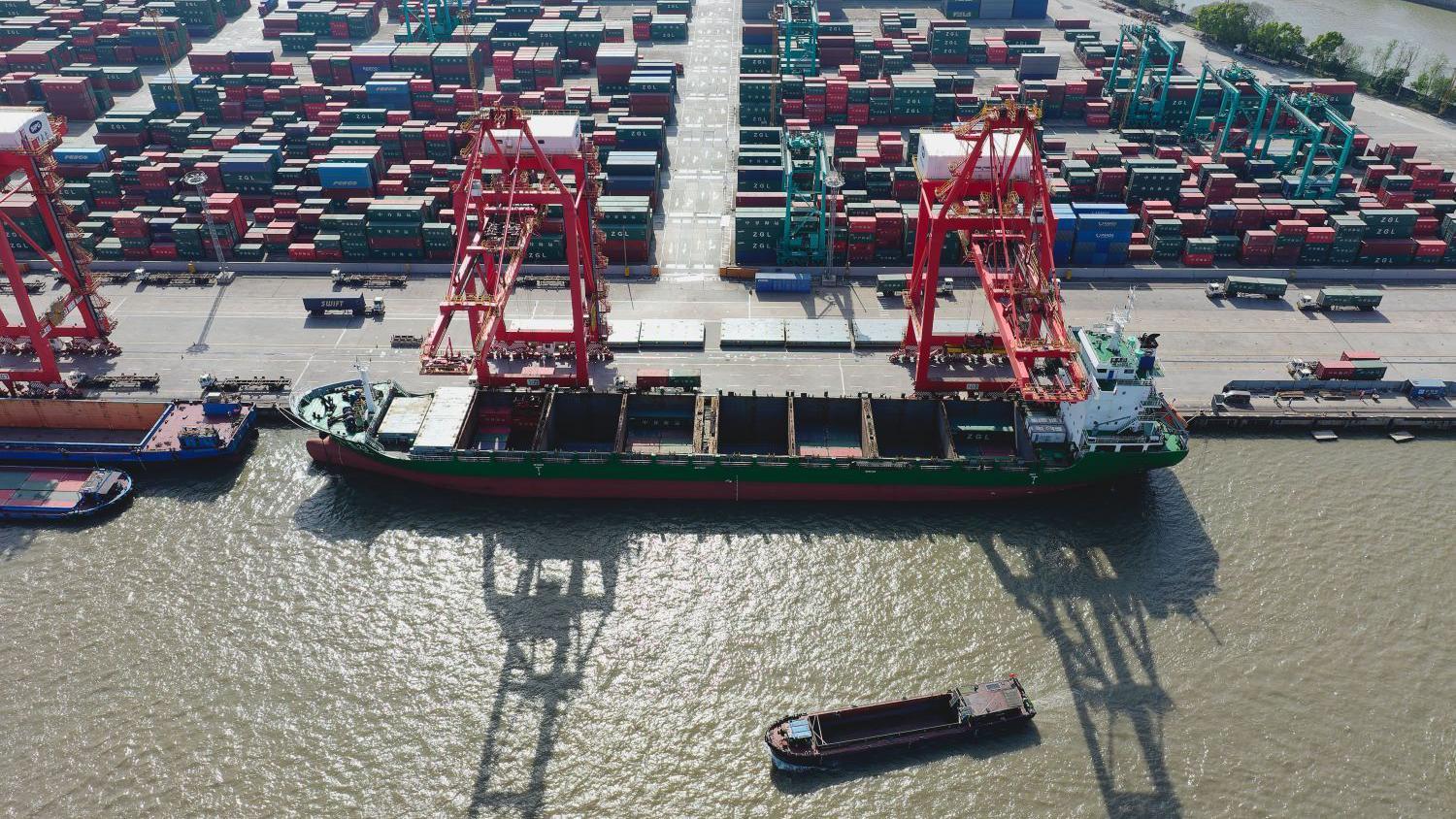 An aerial photo shows cargo ships carrying containers and raw materials sailing close to Shanghai Container Terminal, in Shanghai, China, 18 April 2025. 