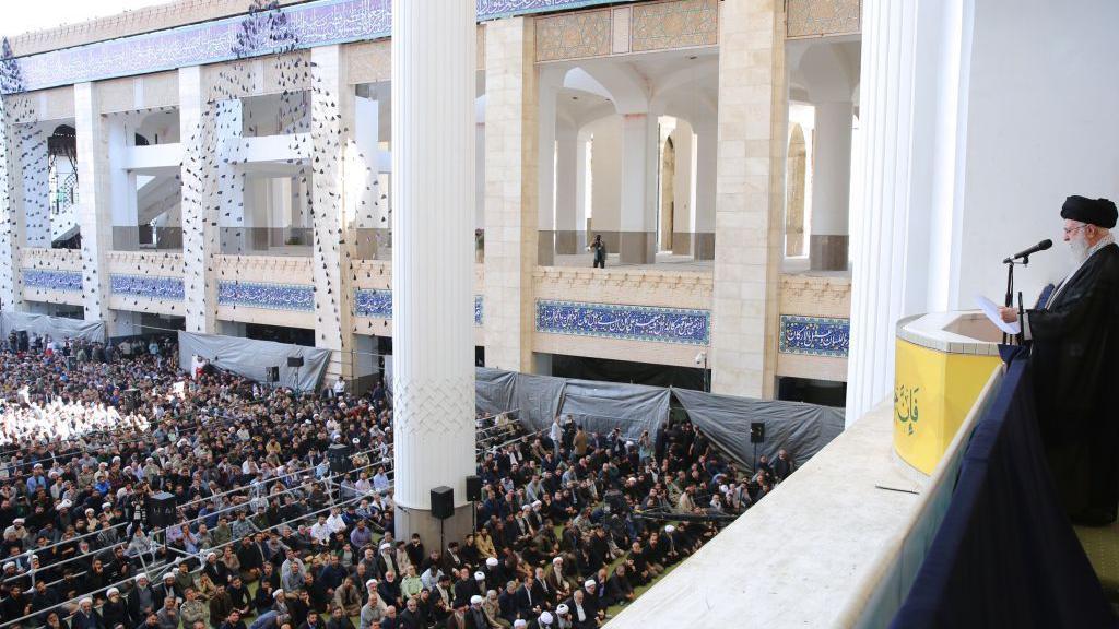 O líder supremo iraniano, aiatolá Ali Khamenei, segura um rifle enquanto lidera a oração de sexta-feira na Mesquita Imam Khomeini Musalla, em Teerã, Irã, em outubro de 2024.