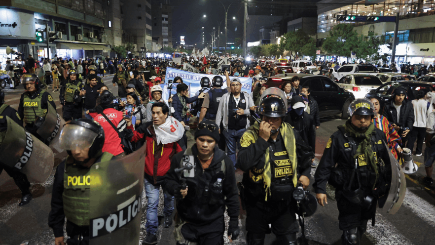 Agentes de policía caminan junto a los manifestantes que participan en una marcha organizada por el colectivo juvenil "Generación Z" para expresar su descontento por una controvertida reforma de las pensiones.