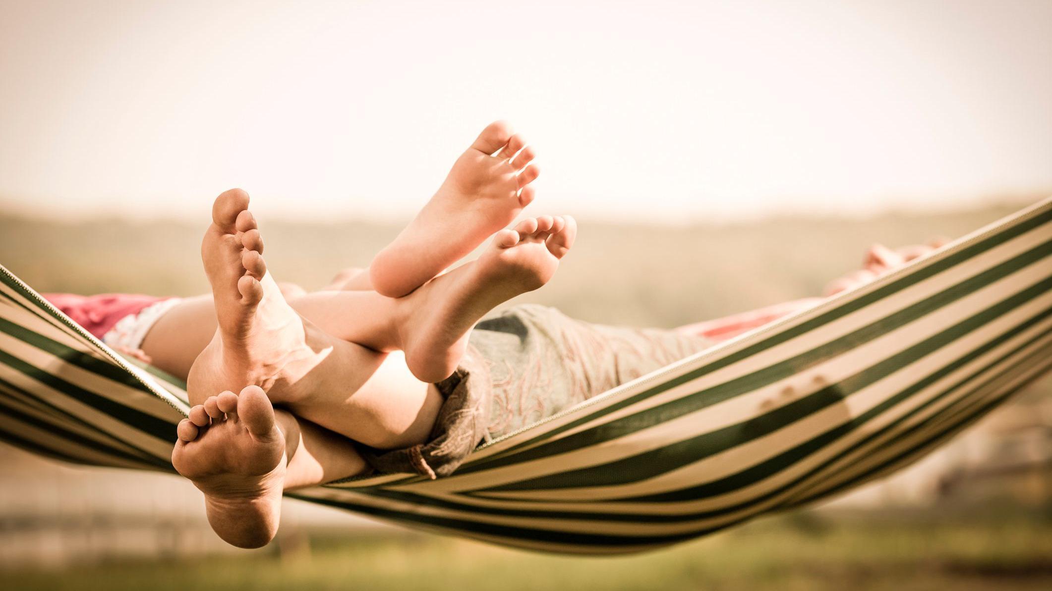 Os pés de uma mãe e filha numa rede