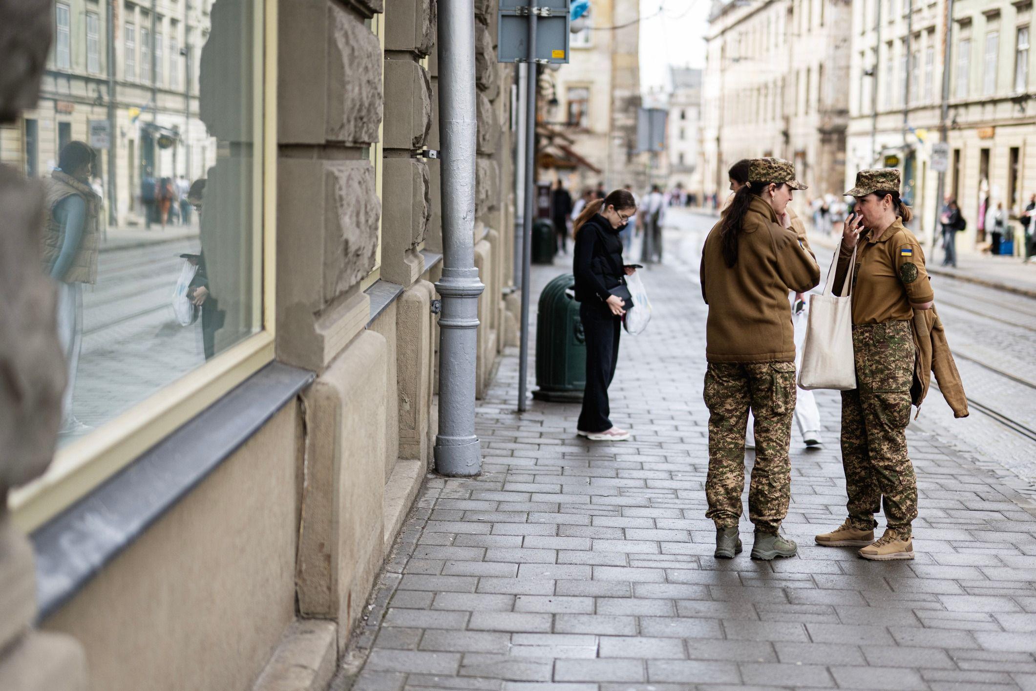 Mulheres militares, vestindo uniforme c&aacute;qui, est&atilde;o em uma rua da cidade de Lviv, na Ucr&acirc;nia