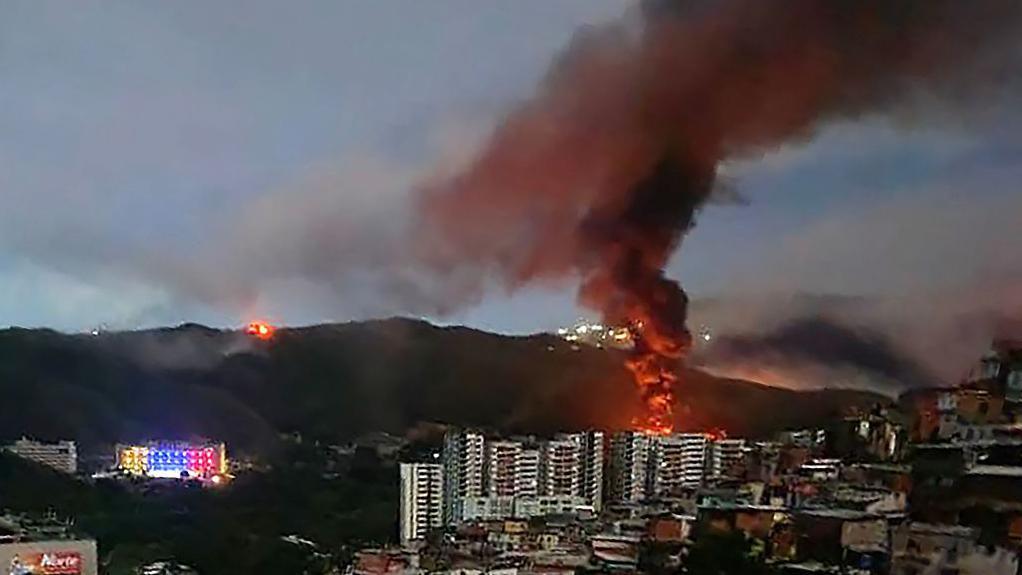 Fire at Fuerte Tiuna, Venezuela's largest military complex, is seen from a distance after a series of explosions in Caracas 