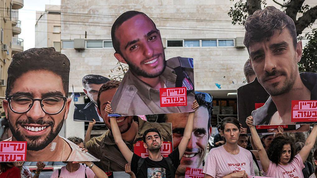 Ljudi drže velike fotografije talaca koje je oteo Hamas na protestu u Tel Avivu 21. juna 2025. 