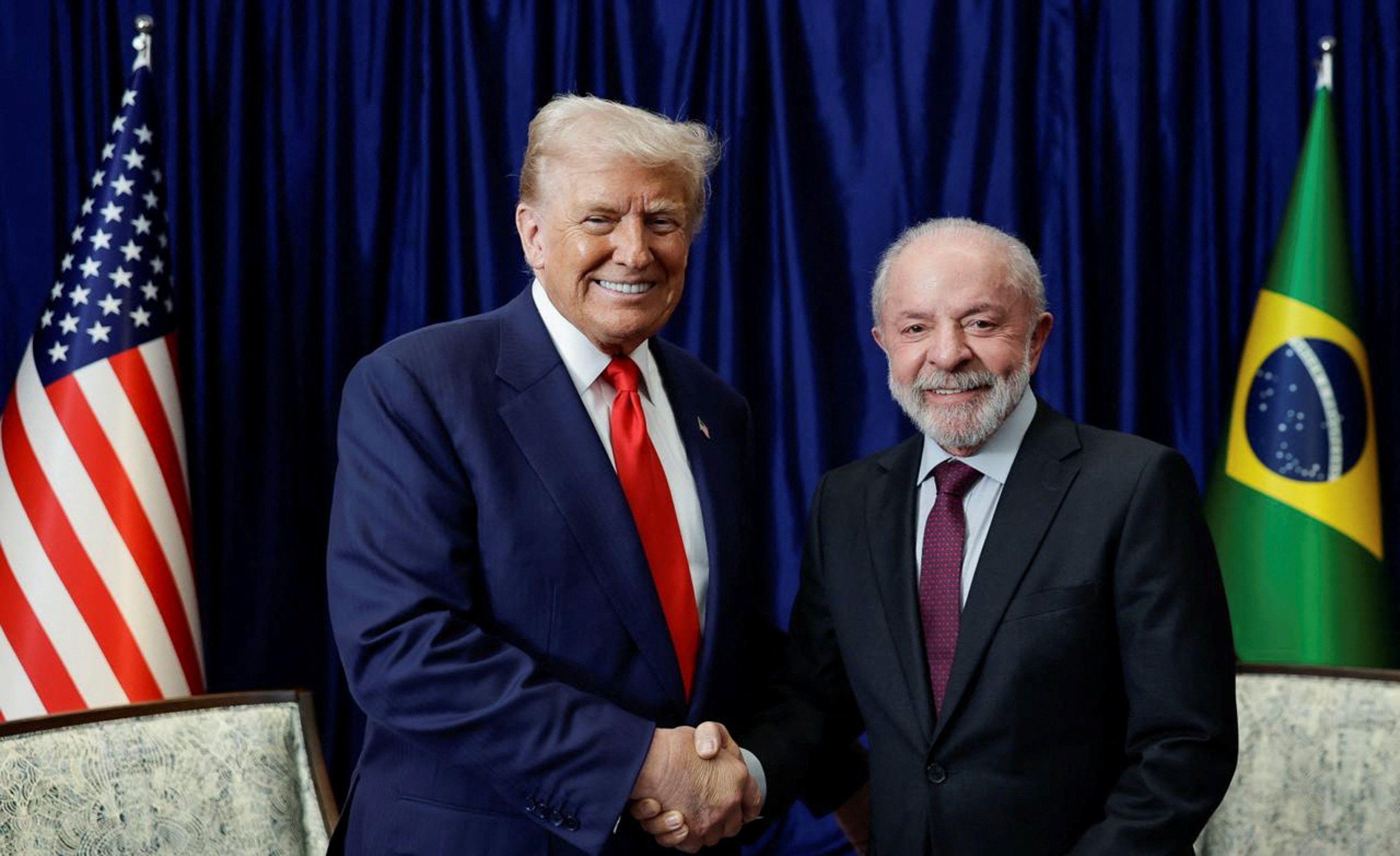 Lula e Trump dando um aperto de m&atilde;o e sorrindo para a c&acirc;mera