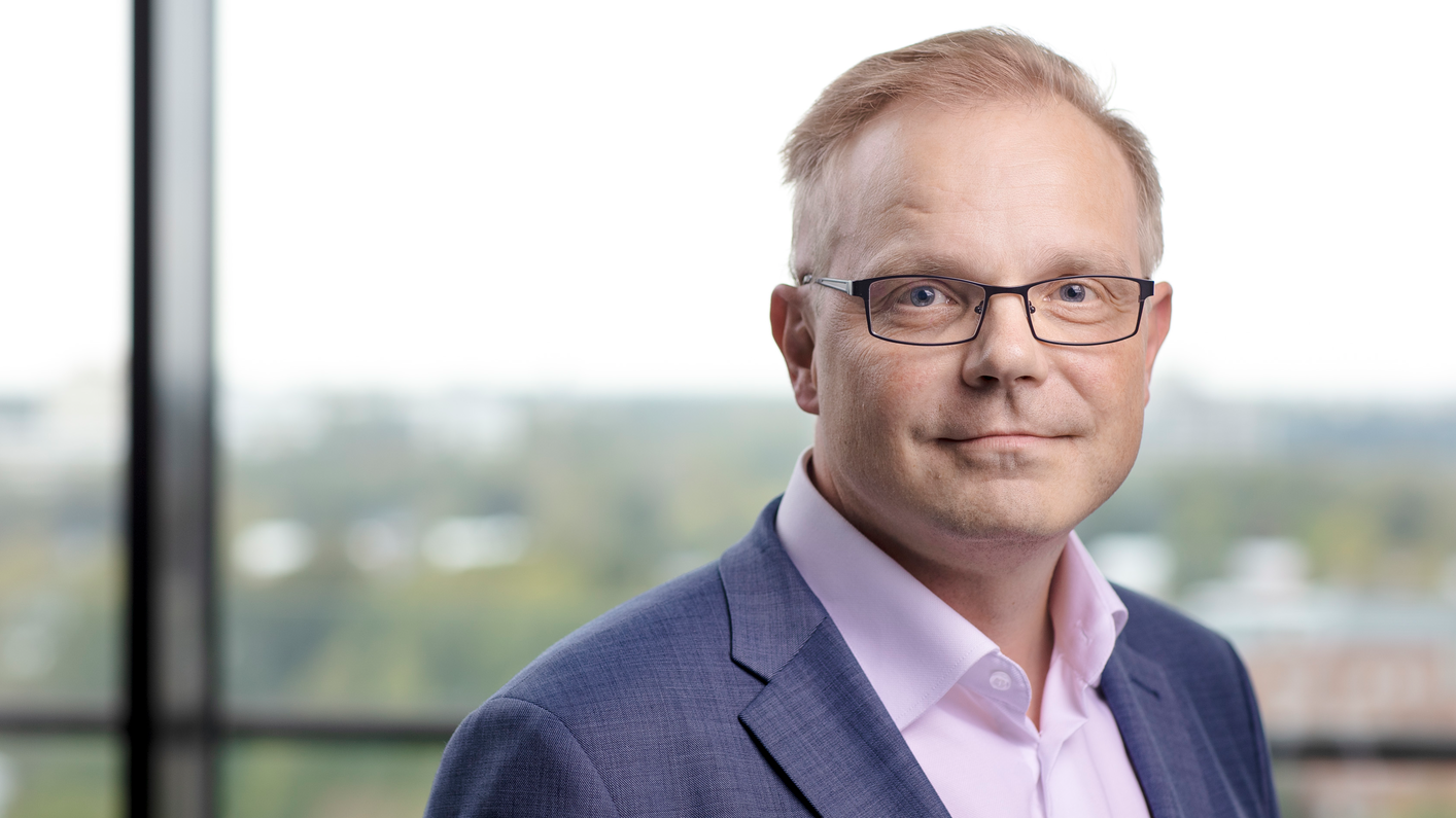 Jyrki Tomminen, ejecutivo del grupo de supermercados Kesko, porta anteojos, un saco gris y una camisa rosada sin corbata