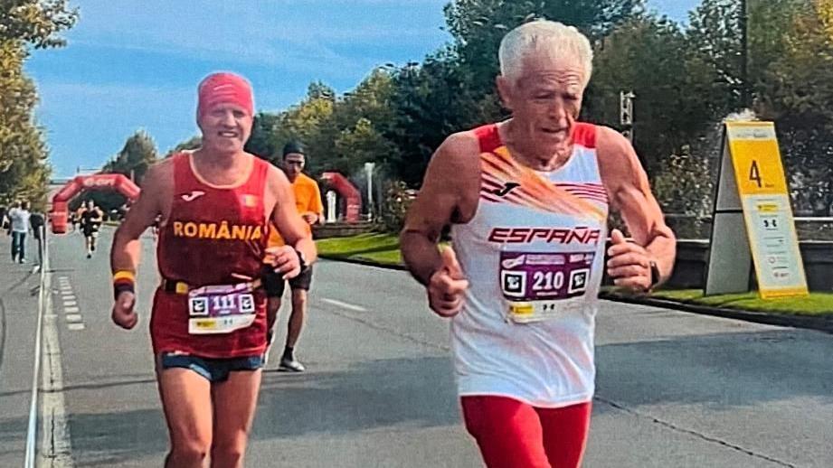 Juan corriendo con una camiseta de España, con un corredor rumano tras él.