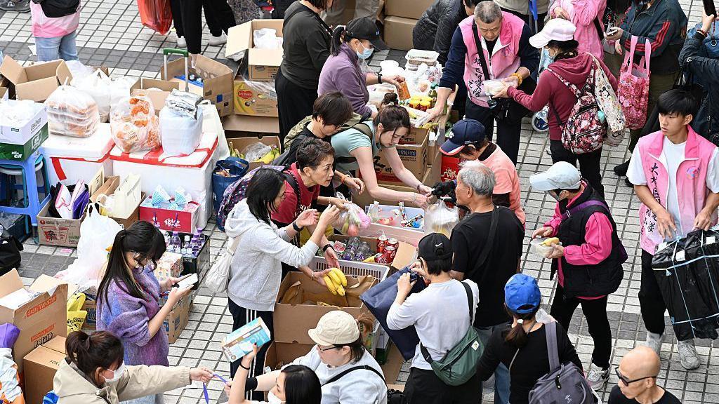 義工在宏福苑多座大廈遭大火波及後，向居民派發食物和飲品。