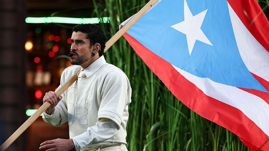 Bad Bunny carregando bandeira de Porto Rico no show do intervalo do Super Bowl, em 8 de fevereiro de 2026, em Santa Clara, Calif&oacute;rnia.