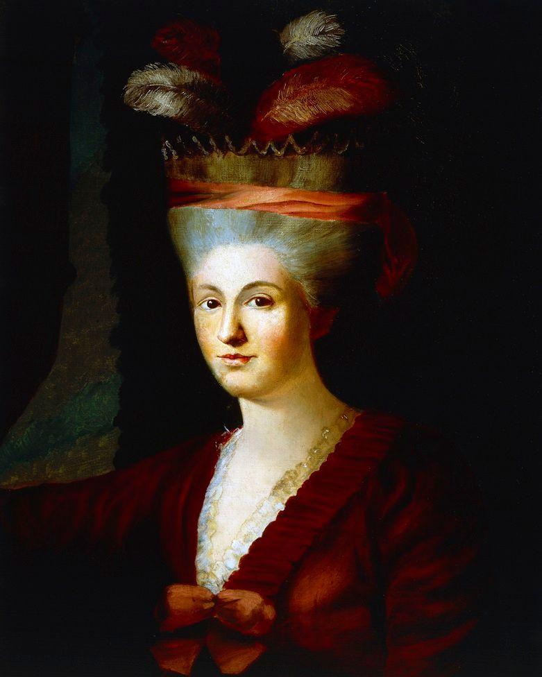 Maria Anna Mozart, Nanerl, posa con un vestido rojo y un bordado blanco en el cuello. En su cabeza lleva una especie de sombrero con unas plumas.