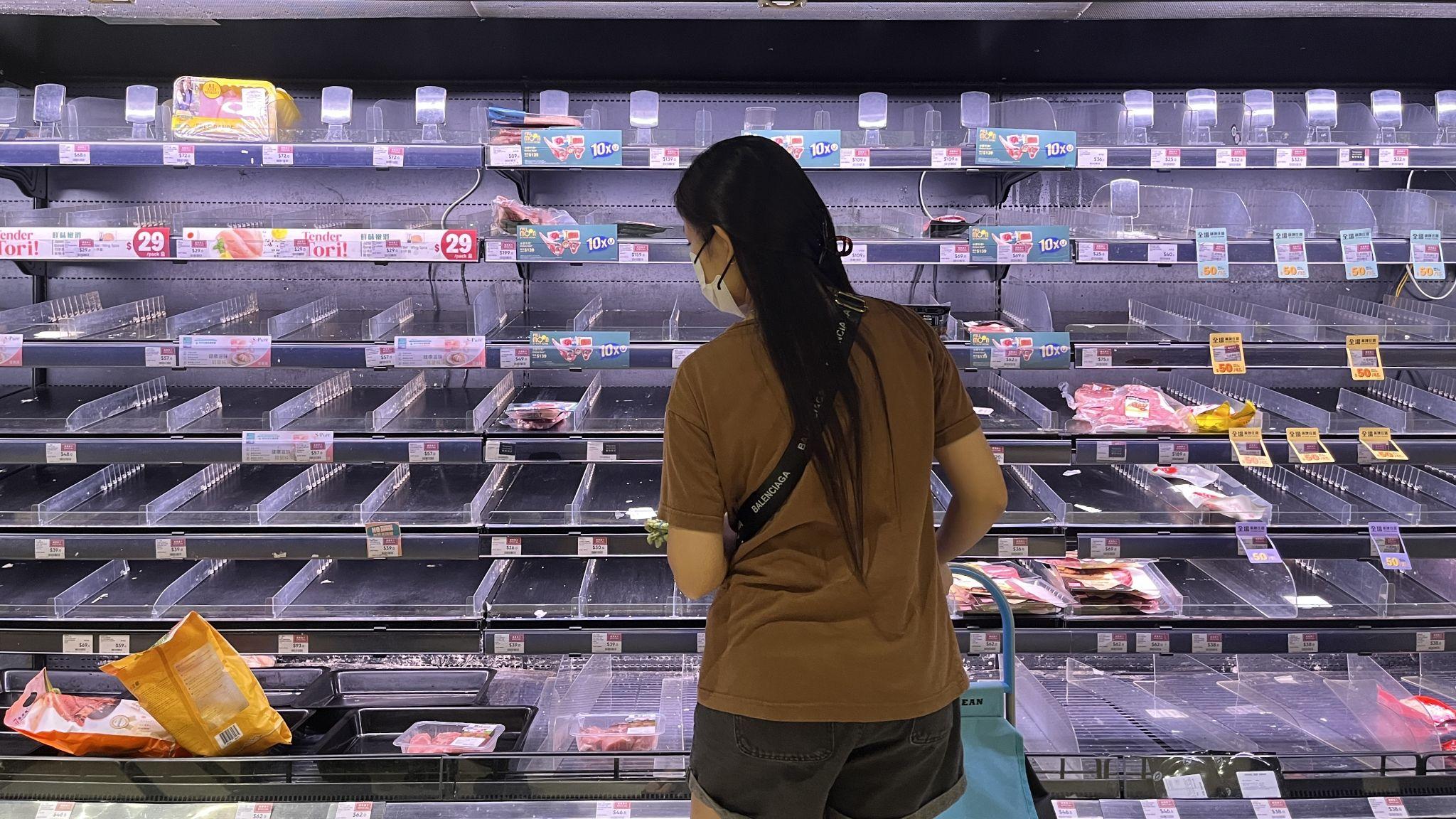 香港將軍澳某超市內一位女士站在已被買空的鮮肉貨架前（BBC中文圖片22/9/2025）